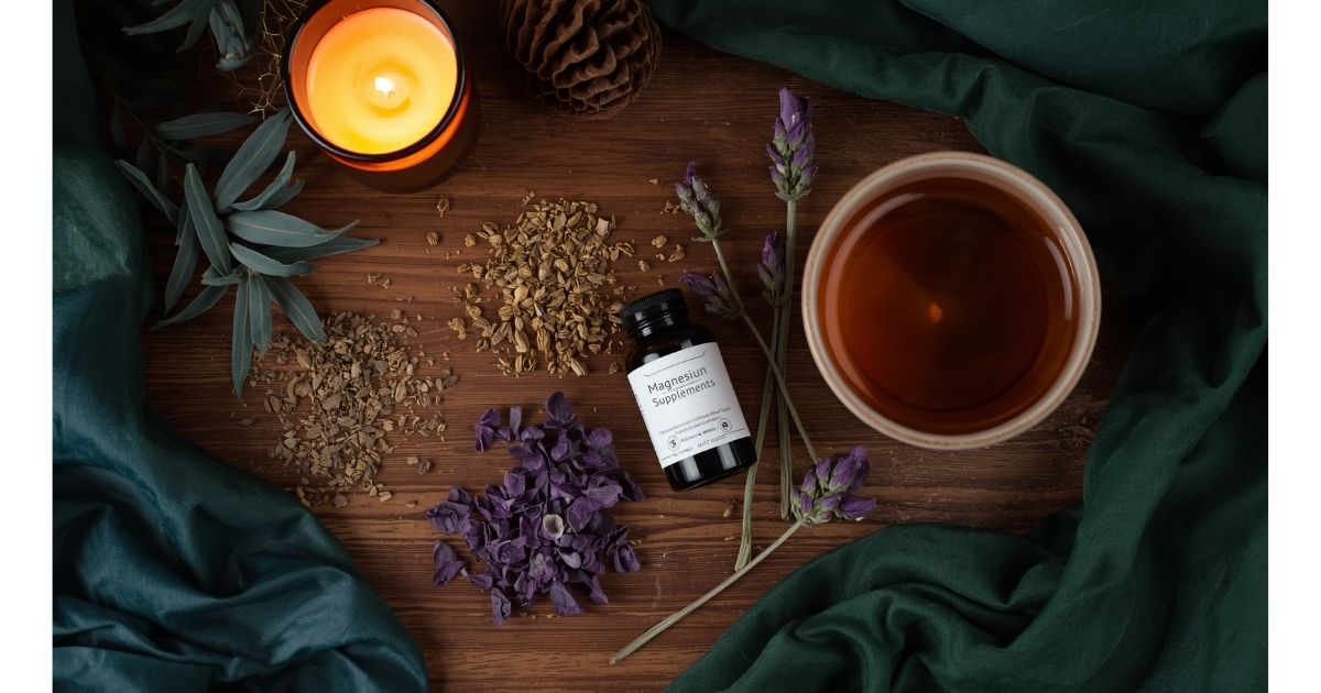 Flat lay of sleep herbs including lavender, valerian and magnesium supplements on wooden surface
